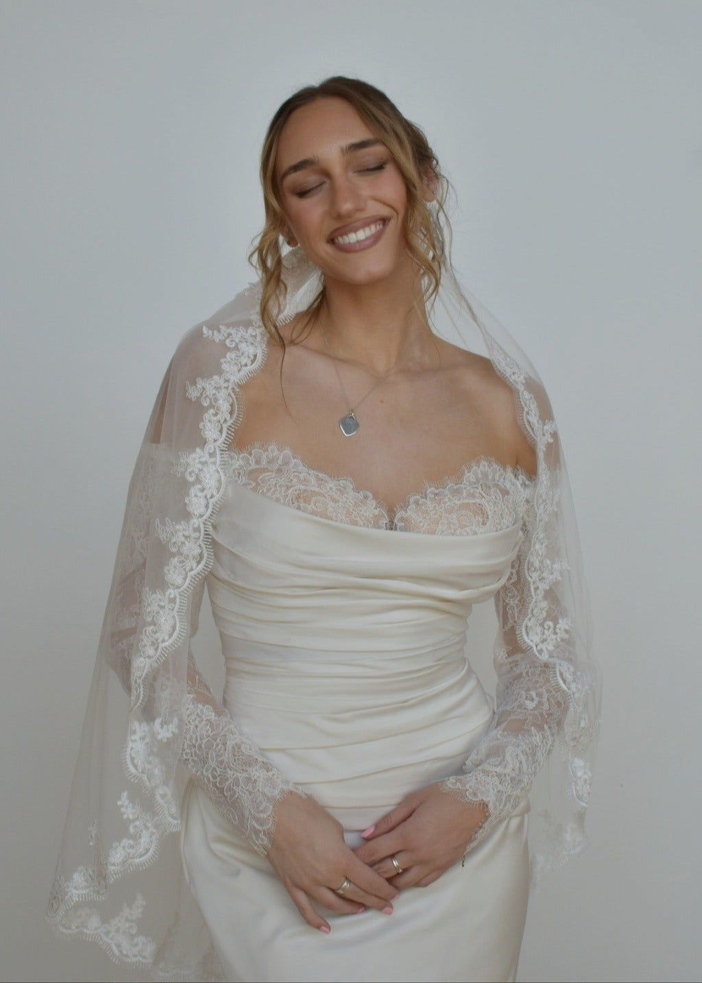 Bride in lace veil with a lace wedding dress