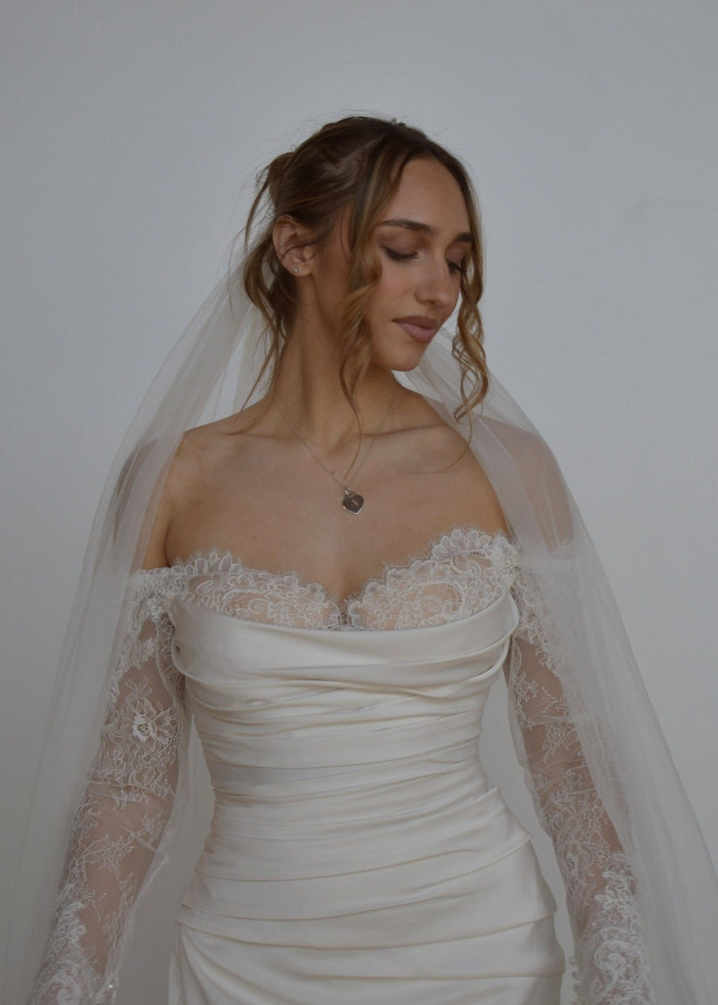 Bride in lace wedding dress wearing tulle veil