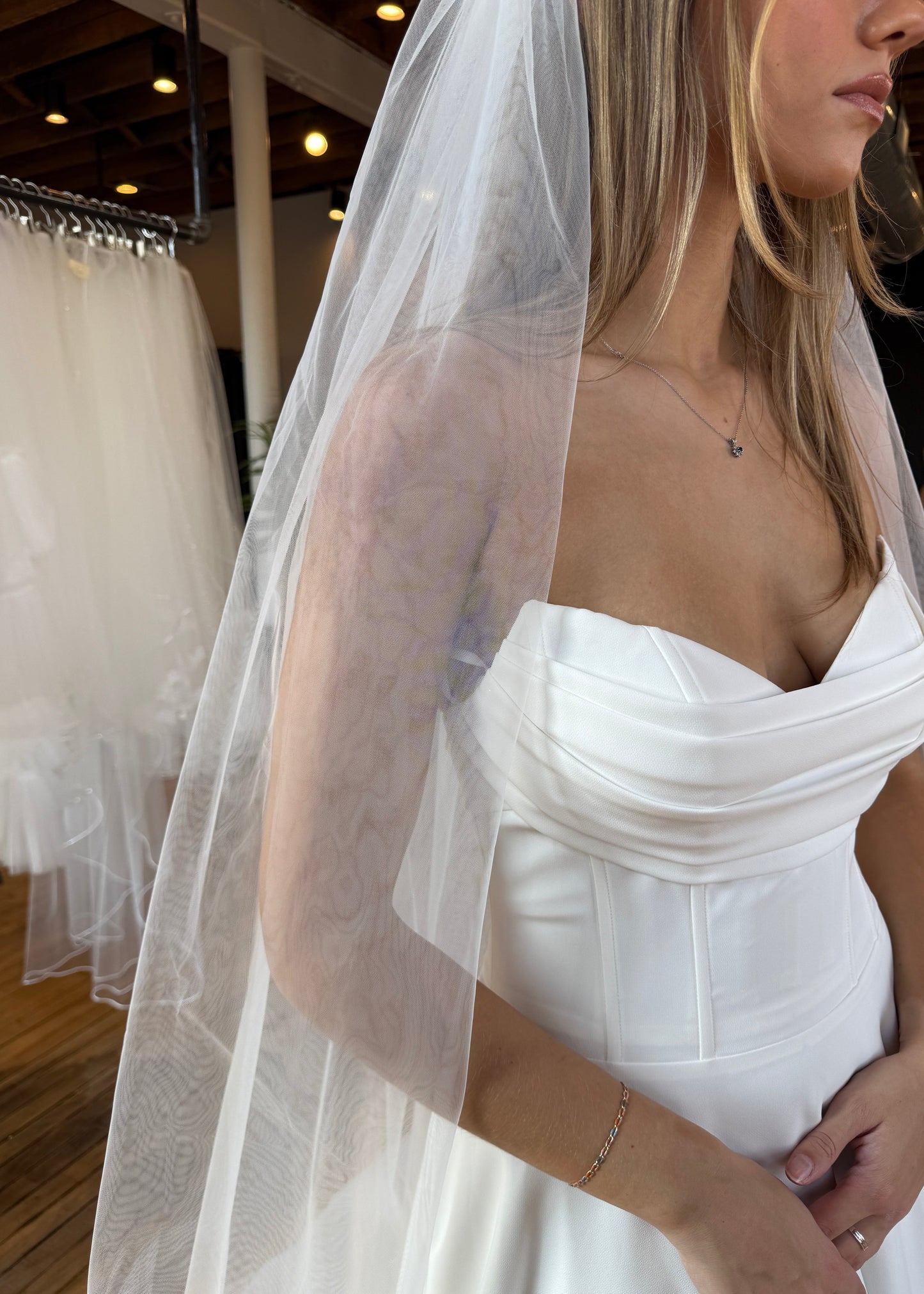 Woman wearing a white dress with a sheer overlay in an indoor setting
