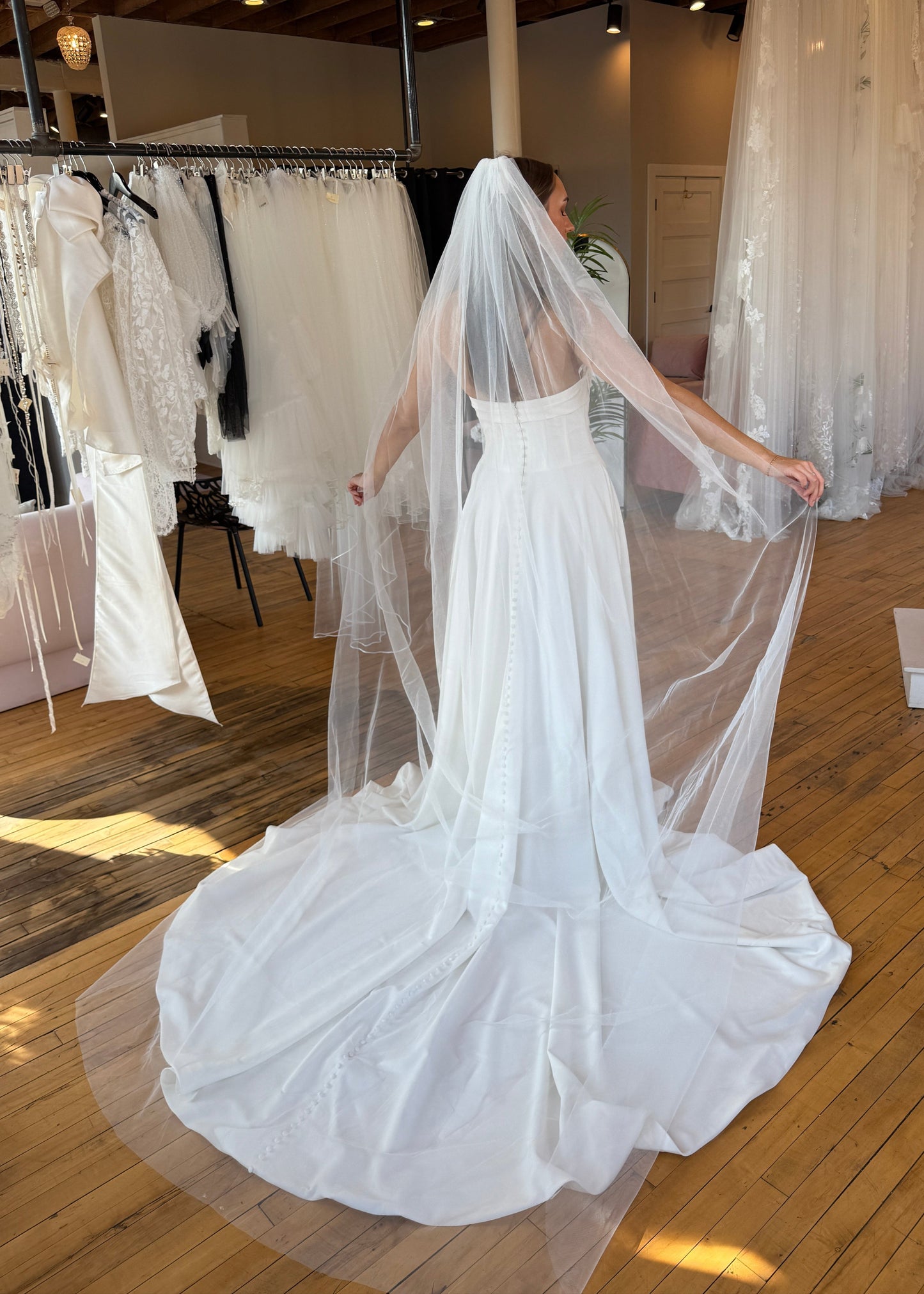 White wedding dress with a long train on display in a store