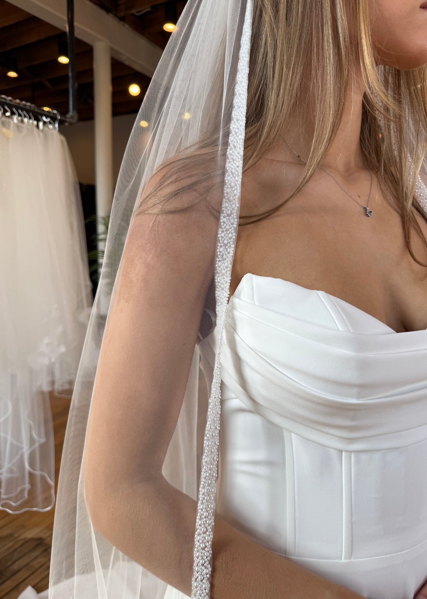 Close-up of a person wearing a white dress with a veil.
