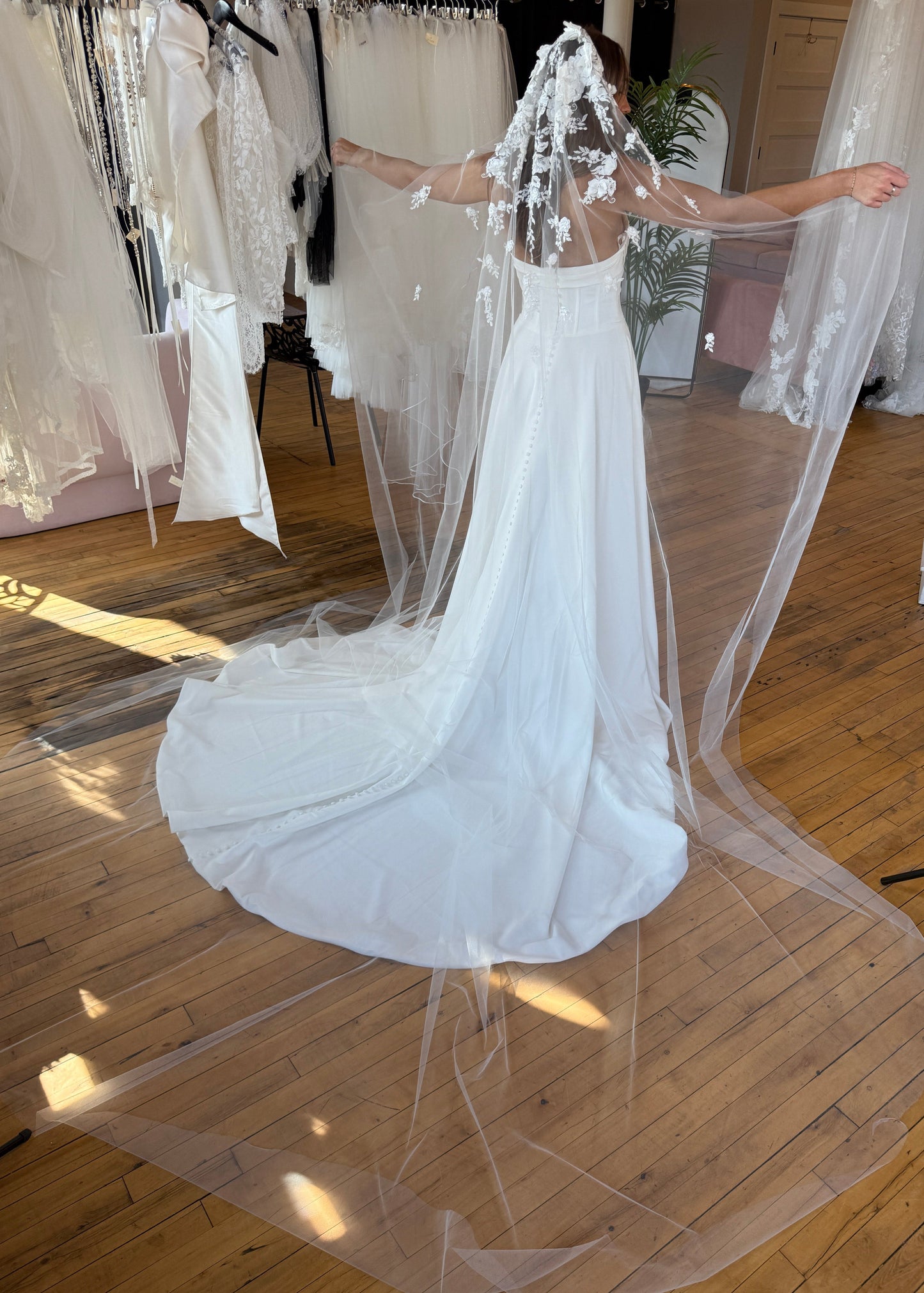 White wedding dress with a long train on a wooden floor