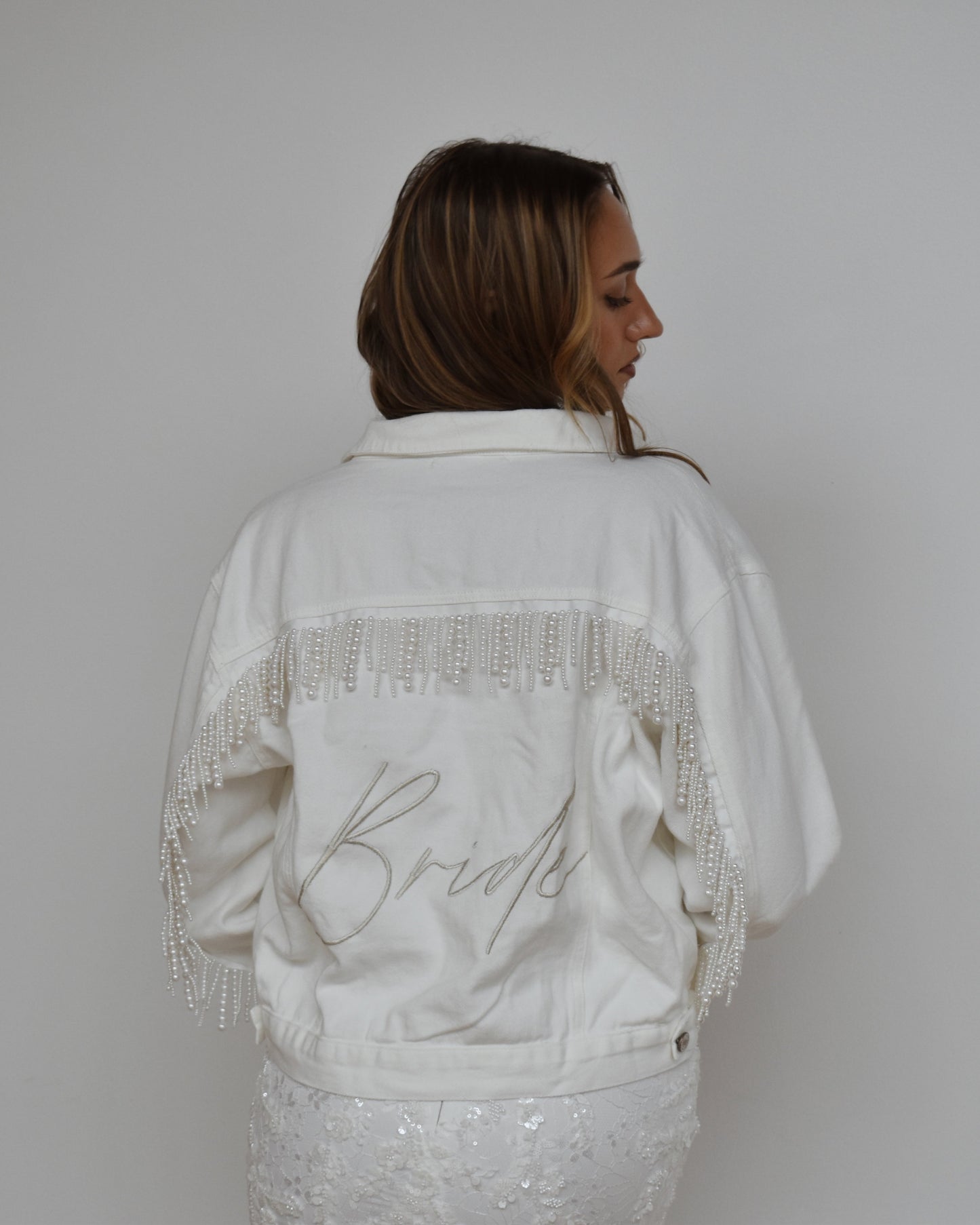 bride wearing white pearl fringe jean jacket