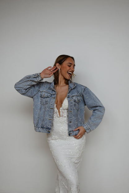 Bride wearing wedding dress and pearl jean jacket