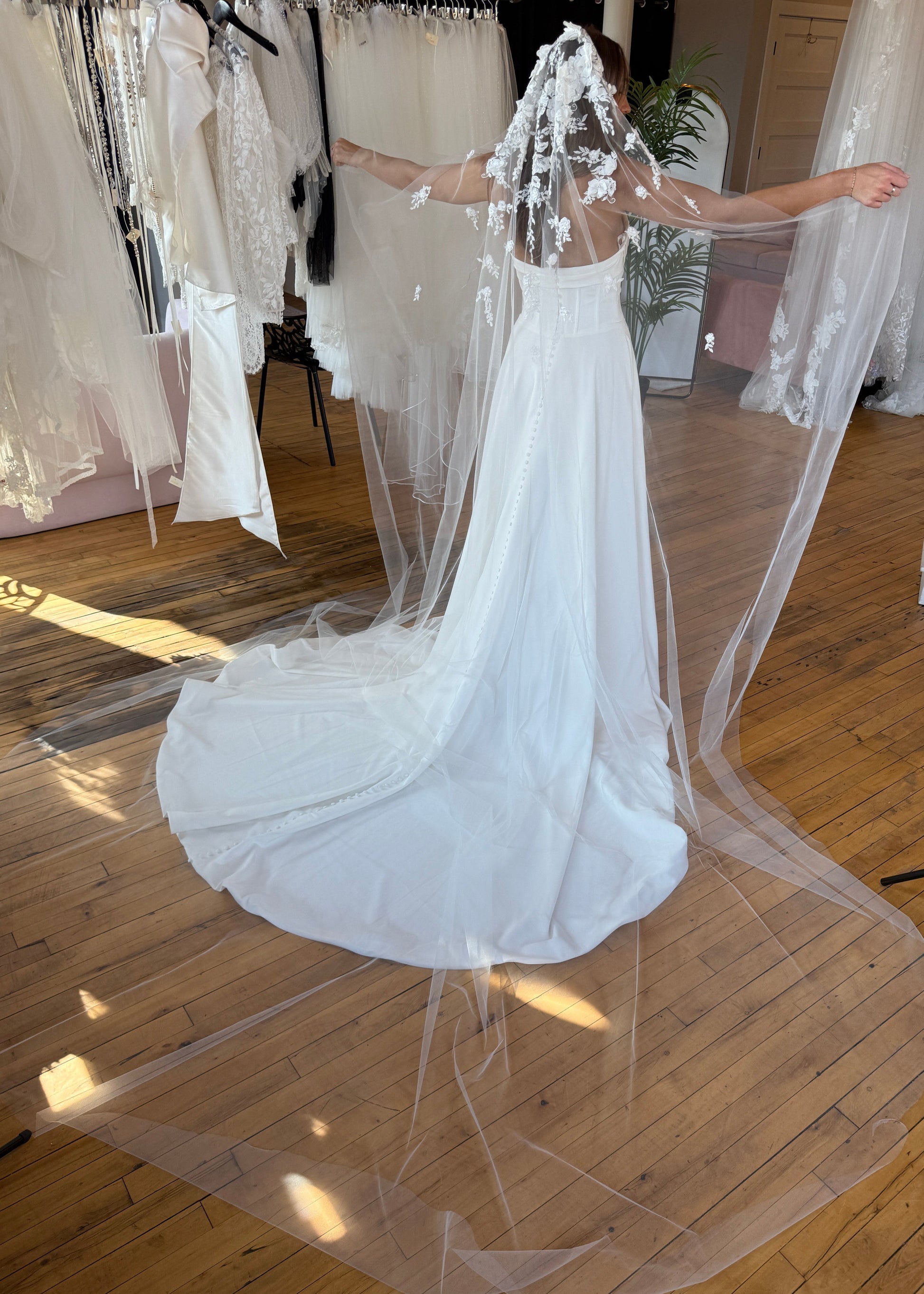 White wedding dress with a long train on a wooden floor