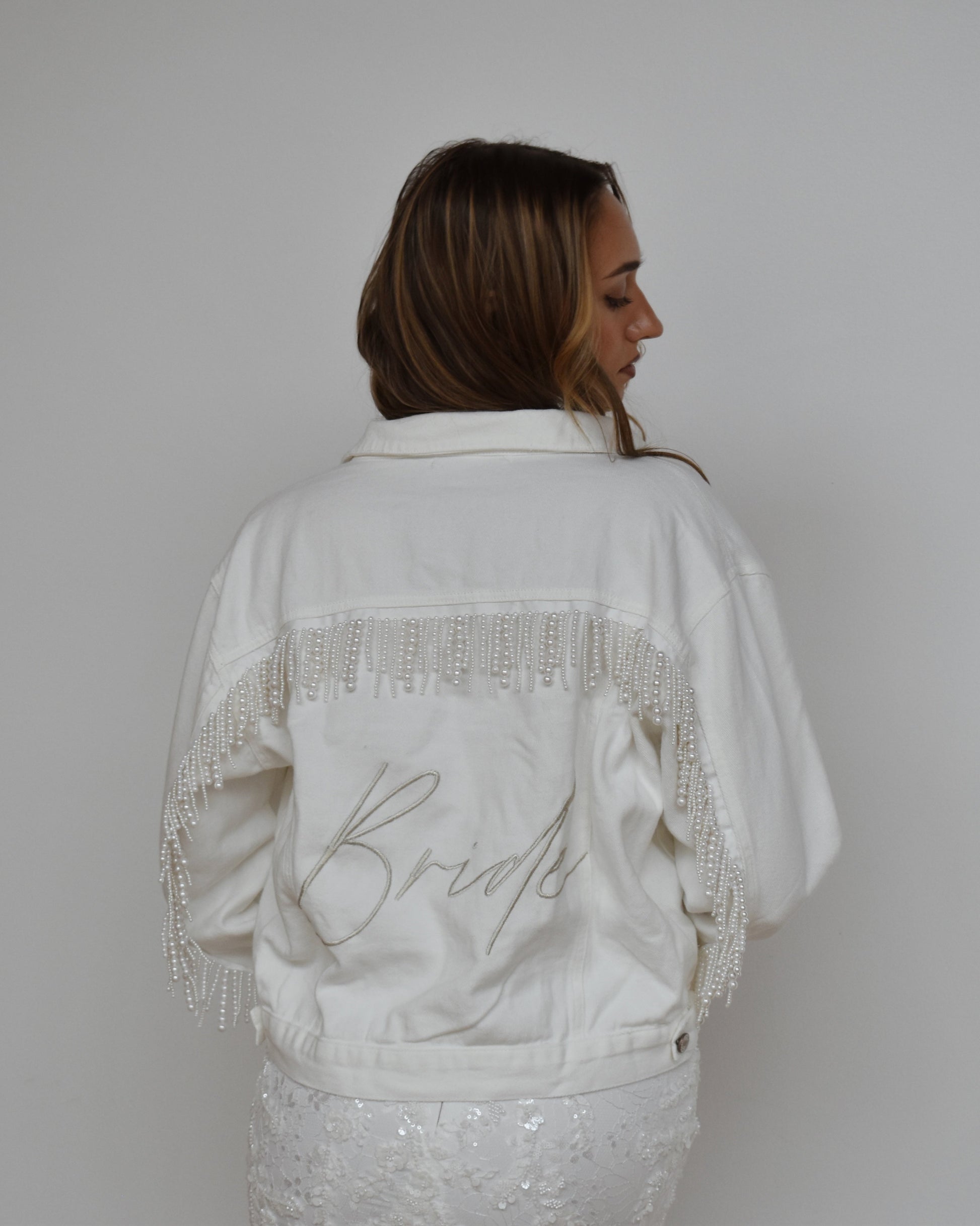 bride wearing white pearl fringe jean jacket
